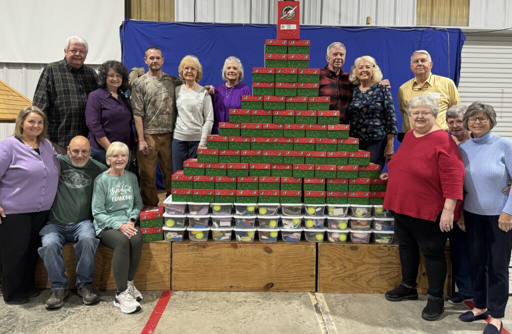 The “crew” standing by the wonderful Christmas tree of 100 boxes packed by our Youth and Children.